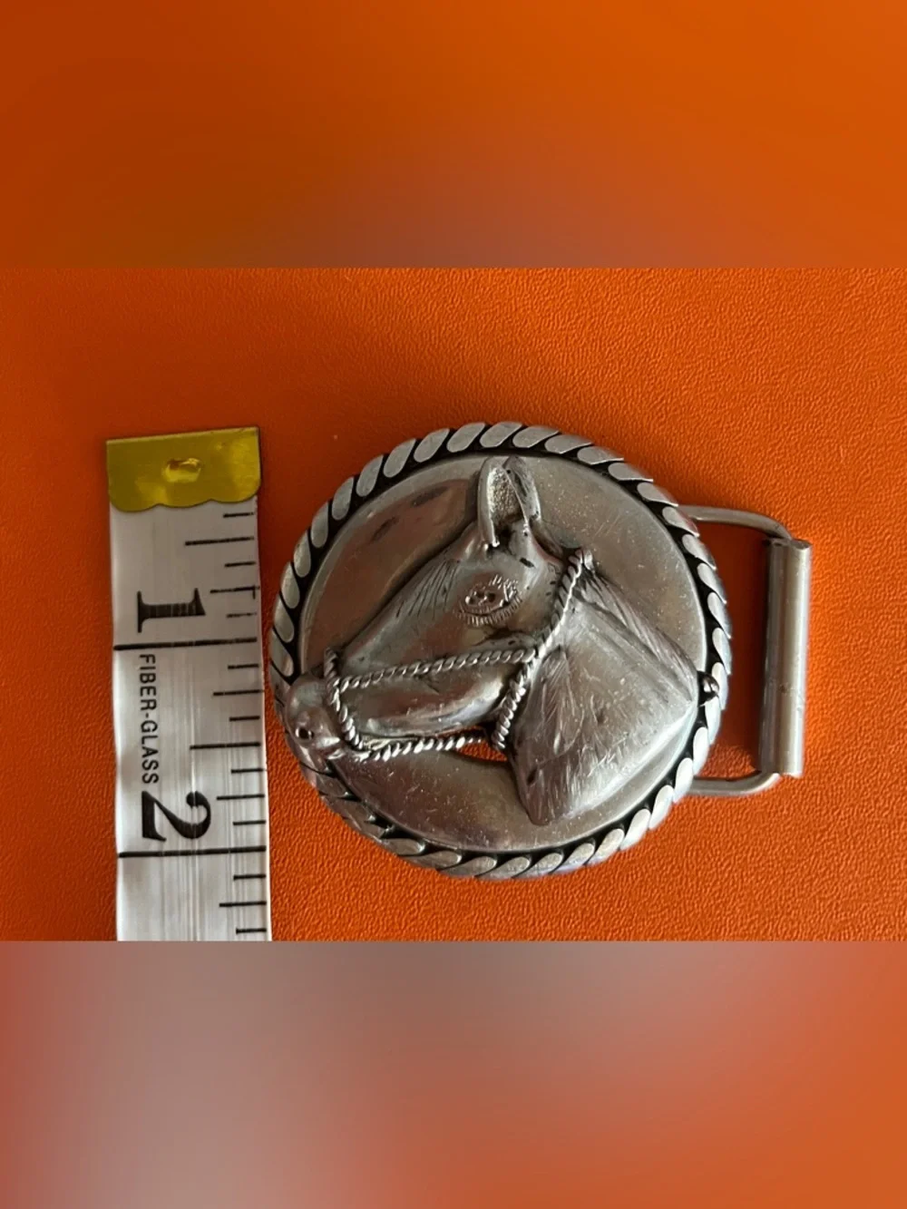 Vintage western-style belt buckle features a sculpted horse head,